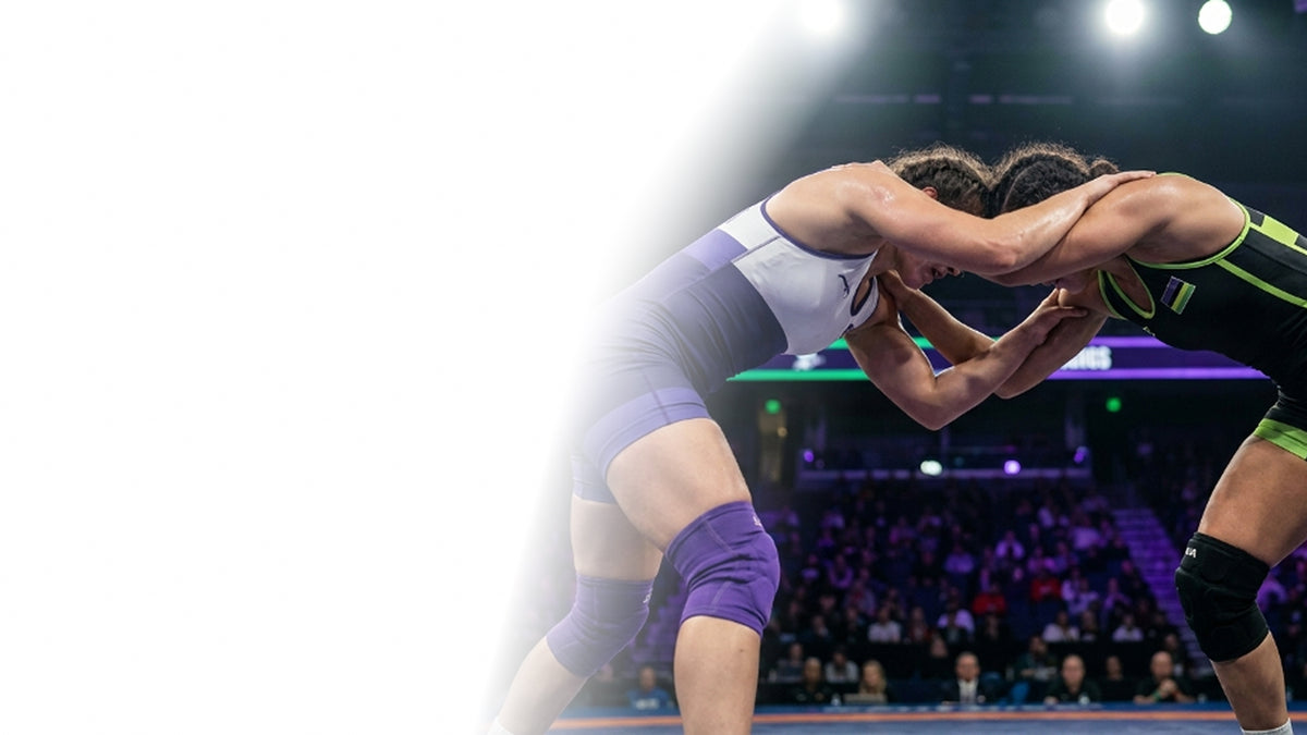 Two wrestlers locked in a tie-up in a packed arena